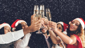 Clinking glasses of champagne in hands, friends greeting New Year, closeup